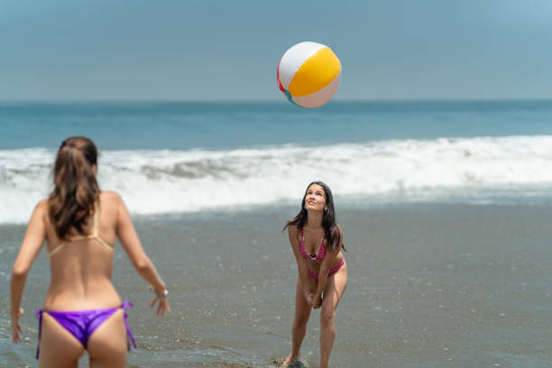 istock Two young women playing beach volleyball on the shore 2194785115