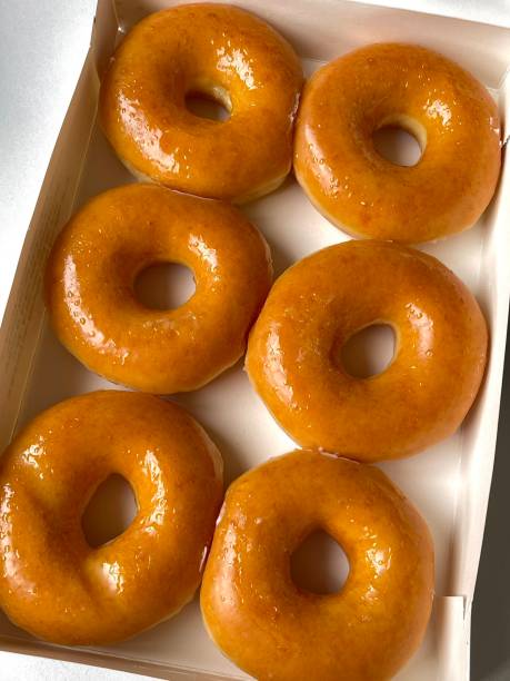 istock A classic glazed donut with a soft, fluffy texture and a sweet, glossy coating. Perfectly balanced between light and sugary, making it an irresistible treat for any time of the day. 2194788794