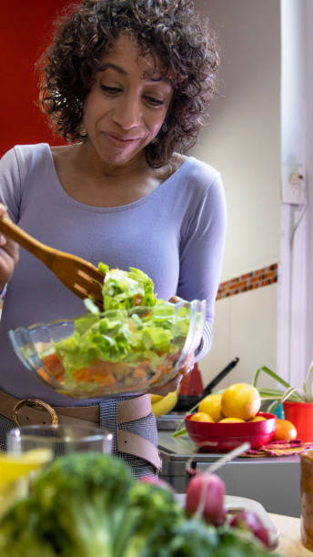 istock Mixed race Woman Preparing a Fresh Salad With Vibrant Vegetables in a Bright Kitchen 2194790462