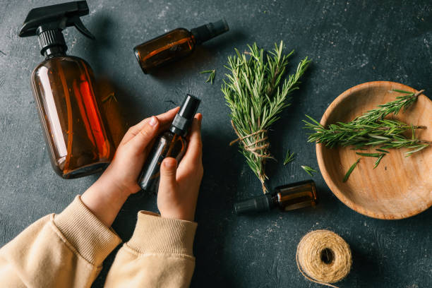 istock Amber glass spray bottle with a black cap placed on a dark rustic surface, surrounded by rosemary sprigs and natural decor elements. Concept of natural, eco-friendly cosmetics or aromatherapy products 2194793471