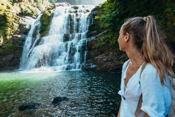 istock Woman Relaxing by Scenic Waterfall in Nature 2194797652