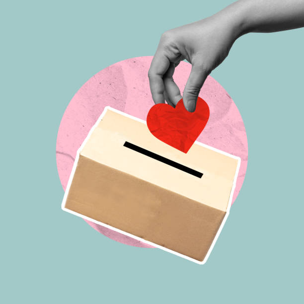 istock A human hand put a red heart to donate a box on a colored background 2194802977