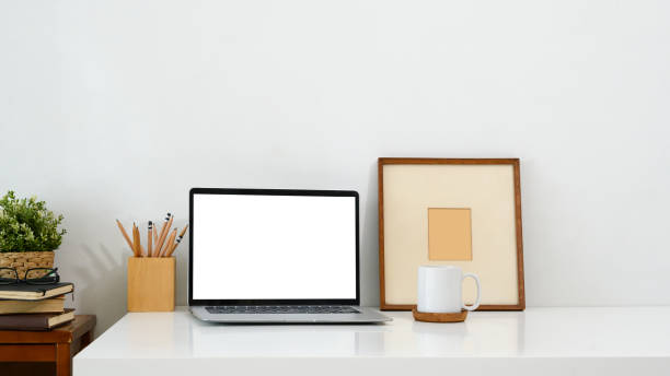 istock Minimalist workspace featuring a laptop with a blank screen, mug, picture frame, and a pencil holder 2194806377