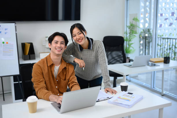 istock Friendly coworkers working together in a modern office and smiling at the camera 2194806547