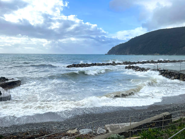 istock Azure sea waves and rocks. Sun rays breaking through clouds. Vacation in Liguria. 2194812783