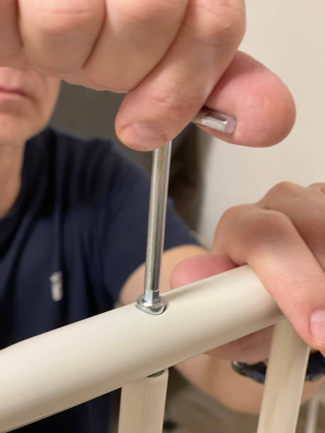 istock Man independently assembles a clothes hanger on wheels. Home improvement. Tools and hobbies. Angled screwdriver. 2194814217