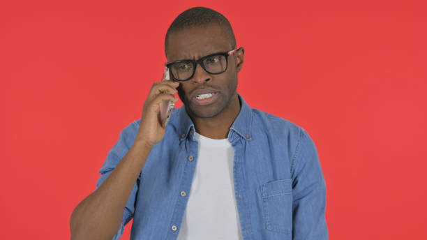 istock Casual African Man Talking on phone on Red Background, Portrait 2194815555