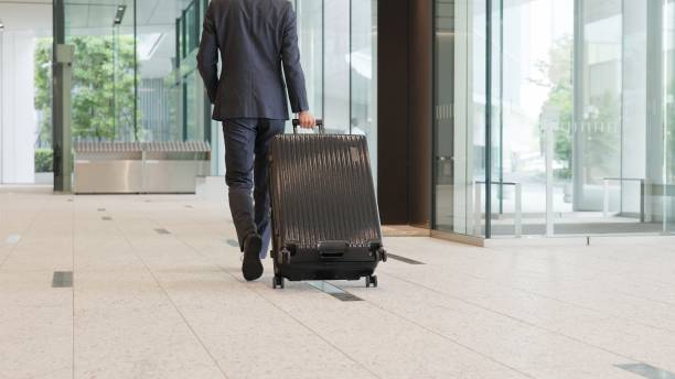 A businessman walking with a suitcase stock photo