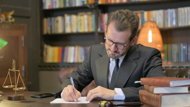 istock Middle Aged Judge Writing Verdict in Office 2194817941
