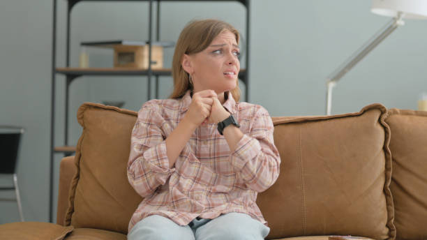 istock Tense Young Woman Sitting on Sofa at Home 2194819080