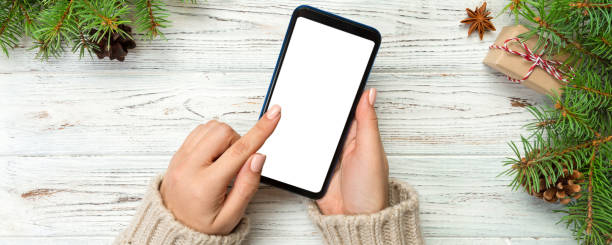 istock Christmas background: female hands messaging smartphone on rustic wooden table background with Christmas decoration. top view, flat lay 2194822274