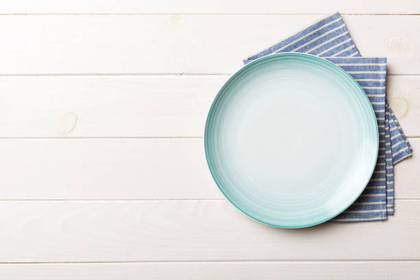 istock Top view on colored background empty round blue plate on tablecloth for food. Empty dish on napkin with space for your design 2194822305