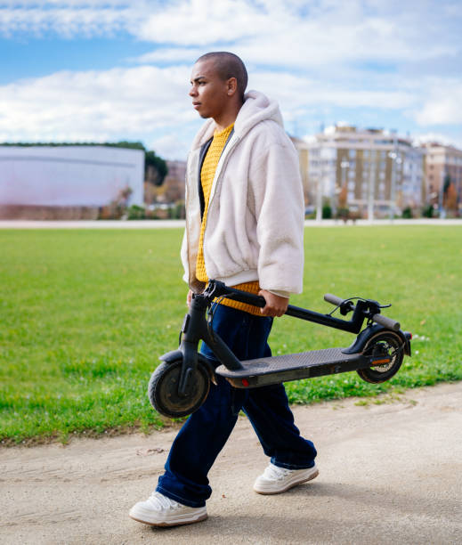 istock Young man carrying electric scooter in a park 2194822645