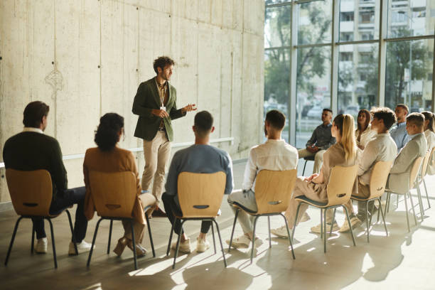 istock Young male leader talking on a group therapy in the office. 2194824127