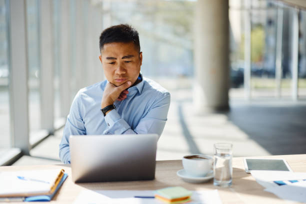 istock Thoughtful Asian businessman working on laptop in the office. 2194824350