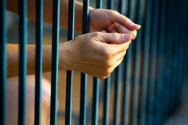 istock Hands Grasping Metal Bars in a Confined Space at Dusk 2194824773