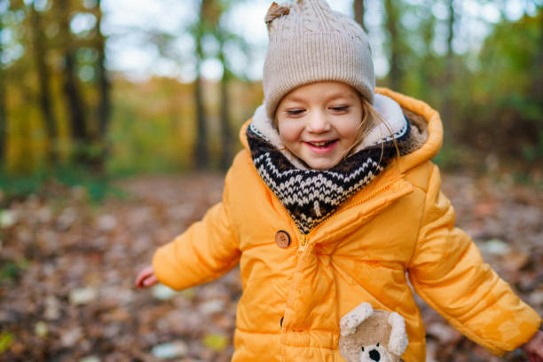 istock Girl in yellow jacket playing in the forest 2194826098