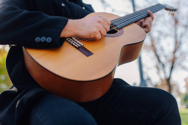 istock Musician playing acoustic guitar outdoors in park 2194826225