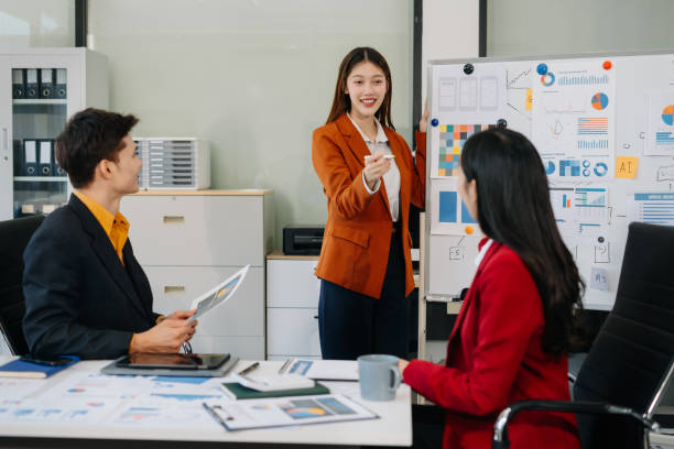 istock Group of professionals participating in meeting or workshop. presenter standing near flip chart give presentation interact with participants, attendee ask questions, share opinion or solutions. 2194826301