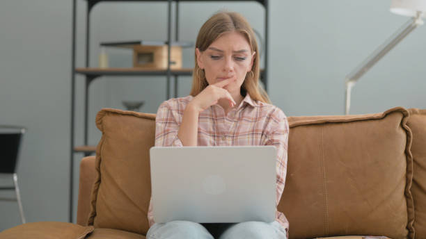 istock Pensive Young Woman Working on Laptop at Home 2194826464