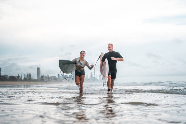 istock Joyful Surfing Couple Running with Surfboards on Gold Coast Beach 2194826654
