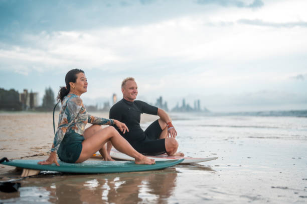 istock Joyful Surfing Couple Relaxing on Gold Coast Beach 2194826673