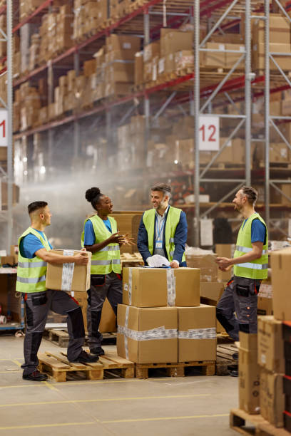 istock Happy inspector talking to his diverse workers in storage room. 2194826892