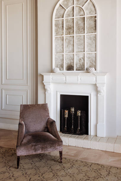 istock A fireplace with a white mantle and a chair in front of it 2194827135