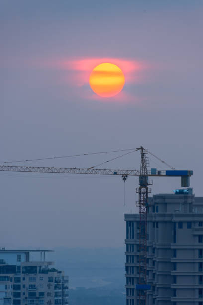 Buildings and cranes at sunrise