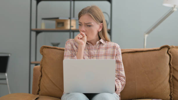 istock Sick Young Woman Coughing while Using Laptop at Home 2194829166