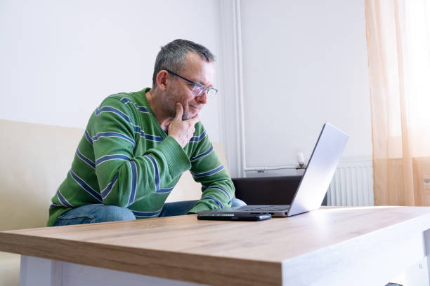 istock Mature man works on a laptop at home. 2194829505