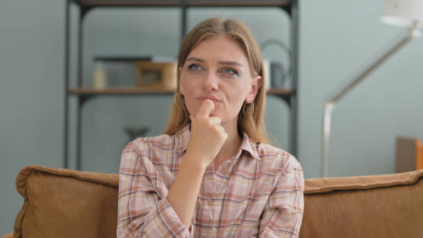 istock Brainstorming Young Woman Thinking while Sitting on Sofa at Home 2194831071