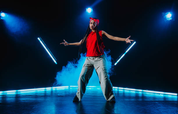 a young black man dancing  in front of a rustic wall background