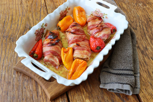 Chicken rolls stuffed with vegetables and cheese wrapped in grilled bacon for holiday dinner.