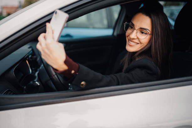 istock Businesswoman taking selfie while driving modern car 2194832572