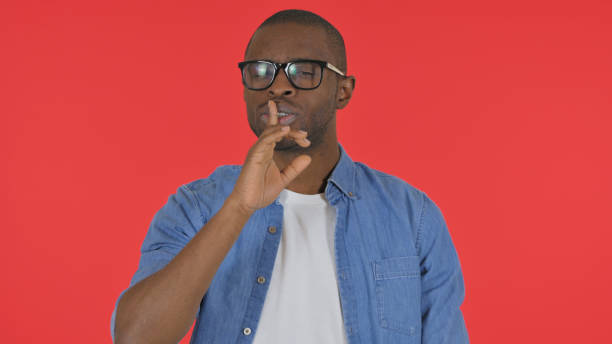 istock Casual African Man with Silence Gesture on Red Background, Portrait 2194834587