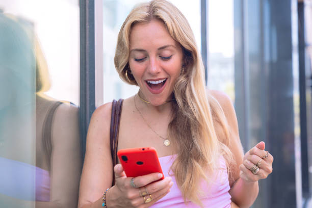 istock Excited young woman looking at her smartphone with joyful expression 2194834948