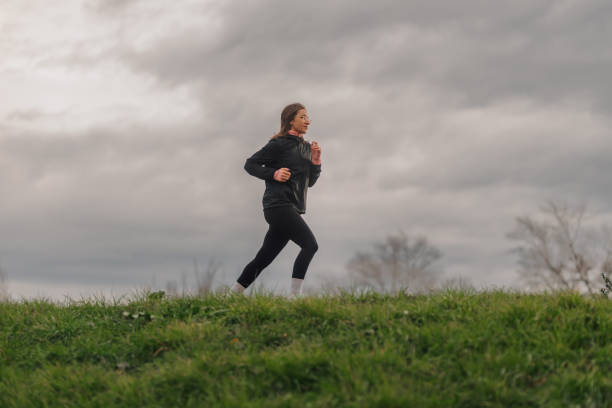 istock Woman running in a park on a cloudy day 2194835001