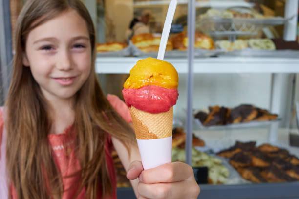 istock Girl holding cone with two scoops of ice cream 2194835159