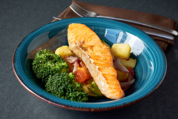 istock Grilled salmon fillet with vegetables on a blue plate 2194835994