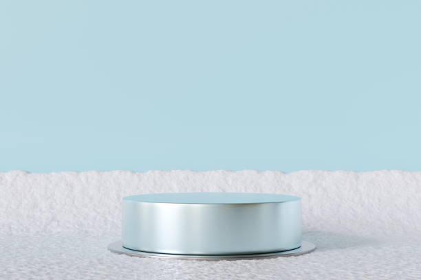 Elegant silver podium on snowy surface with soft blue background, perfect for showcasing products in minimal winter-themed setting. Ideal for holiday campaigns, branding, modern displays. 3D render.