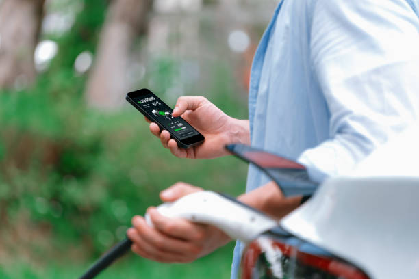 istock Modern eco man recharge EV car with smartphone. Synchronos 2194838928