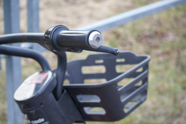 istock A bicycle handlebar with a black basket and shiny details placed against a metal barrier. 2194839912