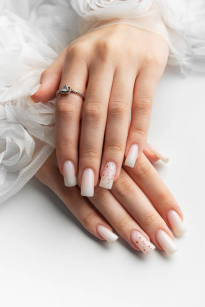 istock Bride showing her beautiful white nails and engagement ring 2194840474