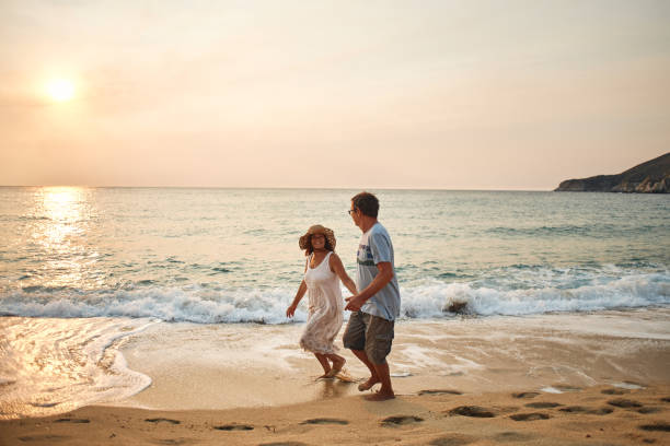 istock Senior couple enjoying walking along the beach 2194845638