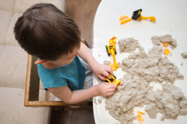 istock The baby boy enjoys building small constructions with kinetic sand during indoor activities. Kid aged three year 2194845681