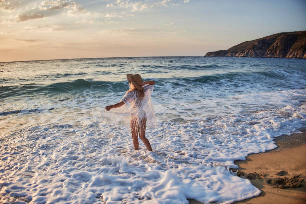 istock Beautiful woman running inside water on the beach at sunset 2194845768
