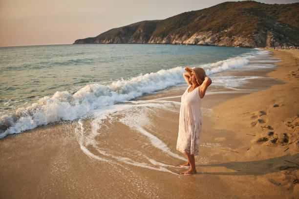 istock Senior woman enjoying walking along the beach 2194845821