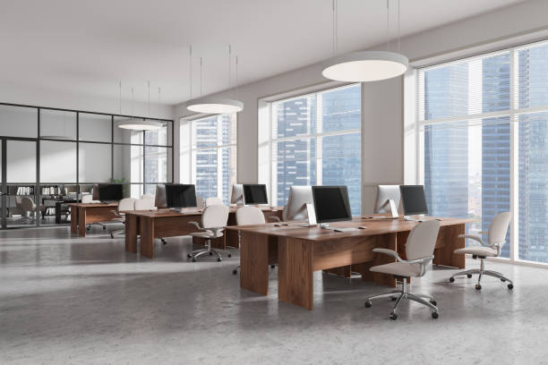 istock Modern open office space with wooden desks, ergonomic chairs, and large windows overlooking city skyline, with gray concrete floor. 3D Rendering 2194847210