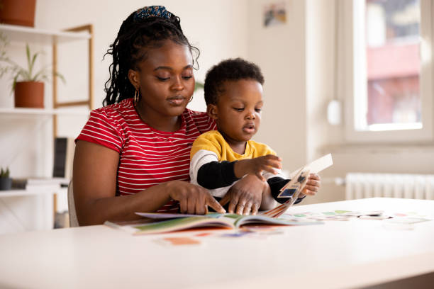 istock Mother and son reading a book together at home 2194855833